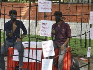 Kashmiri students shows their fingers with red mark as they sit inside a prop cage during a sit-in demonstration against the Indian government's move to revoke the special autonomy of the region guaranteed under Article 370 and 35A, in New Delhi on September 10, 2019. (Sajjad HUSSAIN / AFP)
