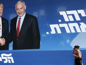 A woman walks past an Israeli election billboard for the Likud party showing US President Donald Trump shaking hands with Likud chairman and Prime Minister Benjamin Netanyahu with a caption in Hebrew reading "Netanyahu, in another league", in the Israeli coastal city of Tel Aviv on September 12, 2019. (AFP)
