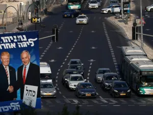 Traffic drives past an Israeli election billboard for the Likud party, showing US President Donald Trump (L) shaking hands with Likud chairman and Prime Minister Benjamin Netanyahu in Jerusalem AHMAD GHARABLI / AFP