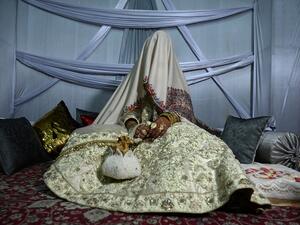 In this photo taken on September 15, 2019, a bride with her face and body covered with a shawl sits in her new husband's home following their marriage in Kashmir's Baramulla district, north of Srinagar. TAUSEEF MUSTAFA / AFP