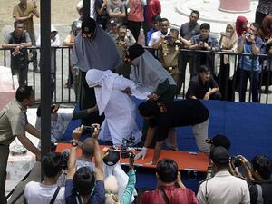 Indonesian woman collapses in pain (Twitter)