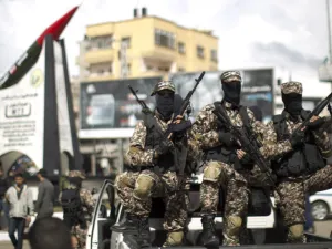 Members of Hamas's military wing pose in front of a M-75 rocket in Gaza. (AFP/ File Photo)