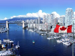 Canadian flag in front of view of False Creek and the Burrard street bridge in Vancouver, Canada (Shutterstock)	