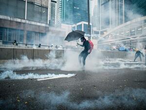 Protesters react after police fired tear gas outside the government headquarters in Hong Kong (AFP)
