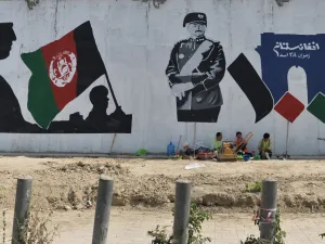 Workers take rest next to a mural of late king of Afghanistan Aman Ullah Khan, who led the successful war for Afghanistan's independence from British Rule in 1919, the day after Afghanistan held presidential elections, in Kabul on September 29, 2019. (AFP/ File Photo)
