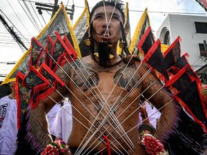 A devotee of a Chinese shrine with multiple needles pierced through his cheeks takes part in a procession during the annual Vegetarian Festival in Phuket on October 4, 2019. MLADEN ANTONOV / AFP