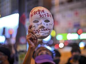 A woman holds a mask with slogans written on as protesters gather outside Mong Kok police station in Hong Kong on October 5, 2019. (AFP/ File Photo)