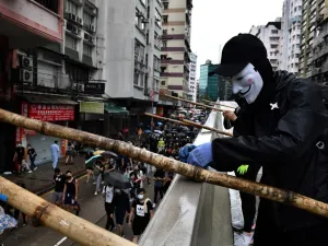 A protester uses bamboo scaffolding to make a road block as others take part in a march through the Tsim Sha Tsui area of Hong Kong on October 6, 2019. (AFP/ File Photo)