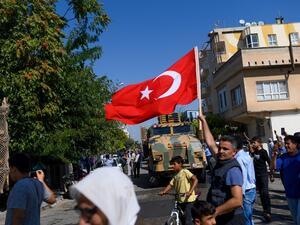 A man waves a Turkish flag as Turkey-backed Syrian opposition fighters enter Tel Abyad from Turkish gate towards Syria in Akcakale in Sanliurfa province on October 10, 2019. (AFP/ File Photo)