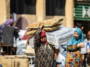 A displaced Syrian woman, who fled her home in the border town of Ras al-Ain, receives humanitarian aid on October 12, 2019, in the town of Tal Tamr in the countryside of Syria's northeastern Hasakeh province. (Delil SOULEIMAN / AFP)