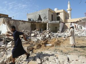 Libyans check the site of an air strike in which three children were killed and others wounded on the southern outskirts of the capital Tripoli (AFP)
