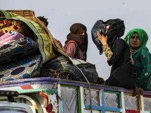 Syrians flee with their belongings the countryside of the northeastern Syrian town of Ras al-Ain on the Turkish border, toward the west to the town of Tal Tamr (AFP)