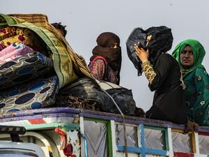 Syrians flee with their belongings the countryside of the northeastern Syrian town of Ras al-Ain on the Turkish border, toward the west to the town of Tal Tamr (AFP)