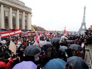 People hold signs and wave Lebanon national flags as they take part in a demonstration to support Lebanese protests, on October 20, 2019 in front of the Eiffel Tower at the Trocadero in Paris. (FRANCOIS GUILLOT / AFP)