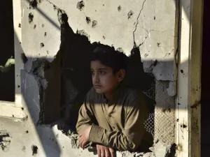 A Kashmiri boy looks out from his damaged family house after cross border shelling in Jura, a village of Neelum valley in Pakistan-administered Kashmir  (AFP)