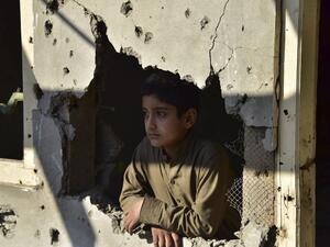 A Kashmiri boy looks out from his damaged family house after cross border shelling in Jura, a village of Neelum valley in Pakistan-administered Kashmir  (AFP)
