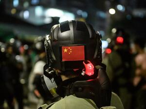 A Chinese flag is displayed on the back of the helmet of a riot police officer during a pro-democracy demonstrator in Yuen Long district of Hong Kong (AFP)