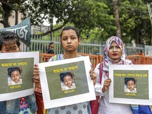 In this file photo taken on April 12, 2019 women hold placards with a photograph of schoolgirl Nusrat Jahan Rafi at a protest in Dhaka, following her murder by being set on fire after she had reported a sexual assault.  (AFP/ File Photo)