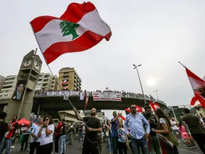 A man waves a Lebanese national flag during a demonstration on the highway that links the capital Beirut to the northern city of Tripoli, in the area of Jal el-Dib in the northeastern outskirts of the capital, on October 26, 2019 on the tenth day of protest against tax increases and official corruption. (JOSEPH EID / AFP)