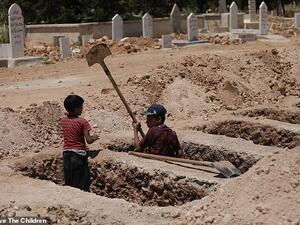 Jawad, eight, and Yazan, 15, should be in school, but they spend their days working as gravediggers and tending to dead bodies with their father Ghassan. (Save The Children)