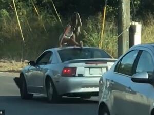 Myscellent Shelton-Cox, 23, was arrested and charged with disorderly conduct early Friday morning for dancing on the roof of a Mustang during slow-moving traffic. (Video Screenshot)