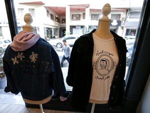 Palestinian feminist fashion items are on display at a shop in Ramallah in the occupied West Bank. The slogan reads in Arabic "a woman's voice shakes mountains". (AFP)