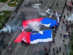 Demonstrators in Santiago carried a torn Chilean flag on October 25, 2019, as sometimes violent protests over both political and economic demands showed little sign of abating. (AFP/ File Photo)