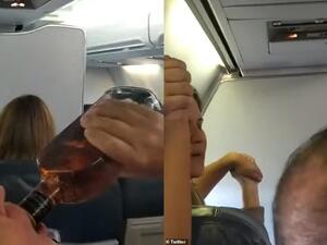 A male passenger drinks from a bottle of whisky after customers on board were notified that the aircraft had engine issues. (Twitter)