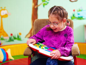 cute girl in wheelchair playing with developing toy in kindergarten for children with special needs (Shutterstock/ File Photo)