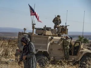 A Syrian elderly woman walks past a US armoured vehicle on patrol in the village of Ein Diwar in Syria's northeastern Hasakeh province on November 4, 2019.  Delil SOULEIMAN / AFP