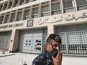 A member of the Lebanese security forces stands at the entrance of the Central Bank after anti-government protesters broke down a construction barrier as they rally at the same time of a press conference held by the bank's governor in Beirut on November 11, 2019. (AFP/ File Photo)