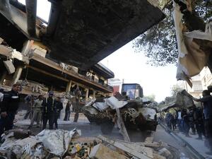 Syrian municipality workers clearing debris from building in Damascus' Mazze neighbourhood following an air strike (AFP)
