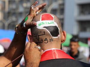 An Iraqi protester has a slogan reading in Arabic: "we need a country" paintend on his head during ongoing anti-government demonstrations on November 13, 2019 at Tahrir square in Baghdad. (SABAH ARAR / AFP)