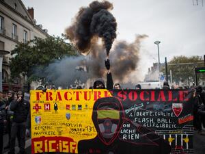 A demonstrator holds a smoke generator during a demonstration marking the first anniversary of the "yellow vest" (gilets jaunes) movement on November 16, 2019, in Nantes, western France. (LOIC VENANCE / AFP)