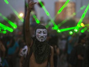 A demonstrator wearing Guy Fawkes mask gestures during a protest against the government, in Santiago on November 18, 2019. (AFP/ File Photo)