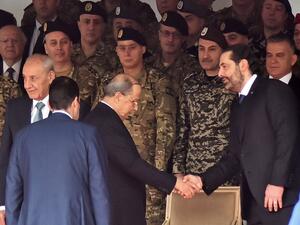 Lebanese President Michel Aoun (C) shakes hands with Prime Minister Saad Hariri (R) while Parliament speaker Nabih Berri (L) stands by, as they attend a military parade commemorating the 76th anniversary of Lebanese independence from France. (AFP/ File Photo)
