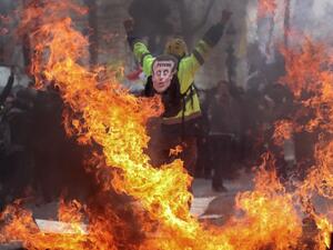 A Yellow Vest protester wearing a mask depicting the French President  (AFP)
