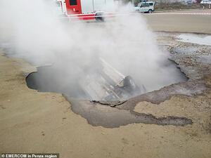 Steam engulfs the car inside the hole in Penza today. 'What an horrendous way to die - one moment you are driving a car, the next underground drowning in hot water,' said one woman. (EMERCOM)