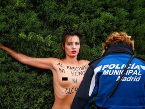 'To fascism neither honour nor glory': A topless woman from the feminist action group Femen stands before a police officer in Madrid today as she demonstrates against the supporters of General Francisco Franco (dailymail)