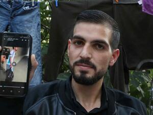 Palestinian Karam al-Qawasmi displays a leaked video showing an Israeli soldier shoot him [AFP/Getty]