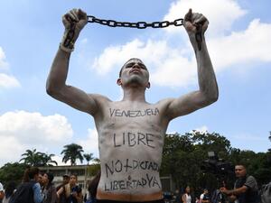A university student holds a chain with his body painted during a protest against Venezuela's President Nicolas Maduro in Caracas on November 21, 2019. (Yuri CORTEZ / AFP)