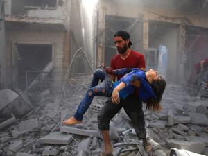 A man evacuates a young bombing casualty after a reported air strike by regime forces and their allies in the jihadist-held Syrian town of Maaret Al-Noman in the southern Idlib province, on May 26, 2019. (AFP/ File Photo)