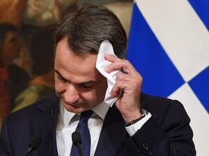 Greek Prime Minister Kyriakos Mitsotakis wipes his forehead during a joint press conference with his Italian counterpart following their meeting at Palazzo Chigi on November 26, 2019 in Rome. Andreas SOLARO / AFP