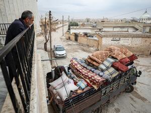 Abu Bilal, a Syrian man from the village of al-Ghadfah in Syria's northwestern Idlib province, watches from a balcony as a truck is being loaded with his belongings on December 1, 2019, before departing from the village towards Azaz in the north of Aleppo province following recent military developments in Idlib. (Omar HAJ KADOUR / AFP)