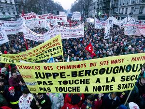 People hold banners during a demonstration against French Prime Minister Alain Juppe's welfare reform plan continue in Paris on December 12, 1995. JOEL ROBINE / AFP