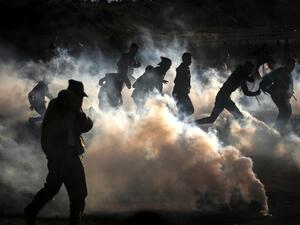 Palestinian protesters run from tear gas fired by Israeli forces amid clashes during a demonstration along the border with Israel east of Bureij in the central Gaza Strip on December 6, 2019. MAHMUD HAMS / AFP