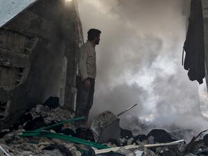 A man stands before a cloud of dust amidst rubble in a collapsed building following a reported air strike in the village of Balyun in Syria's northwestern Idlib province on December 7, 2019.  (AFP/ File Photo)