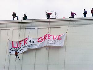 Demonstrators deploy a banner saying "UFR on strike", on the roof of a building, on November 12, 1995, in Caen, during the national strike movement against several cuts by the government in the welfare and pensions systems. Mychele DANIAU / AFP