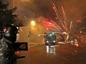 Supporters of Lebanon's Shiite Hezbollah and Amal groups hurl fireworks at security forces early on December 17, 2019 in central Beirut. Lebanon's president yesterday postponed consultation to select a new prime minister after weeks of largely peaceful street protests descended into weekend violence. ANWAR AMRO / AFP