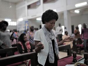 Sudanese Christian woman prays during a Sunday service (AFP)